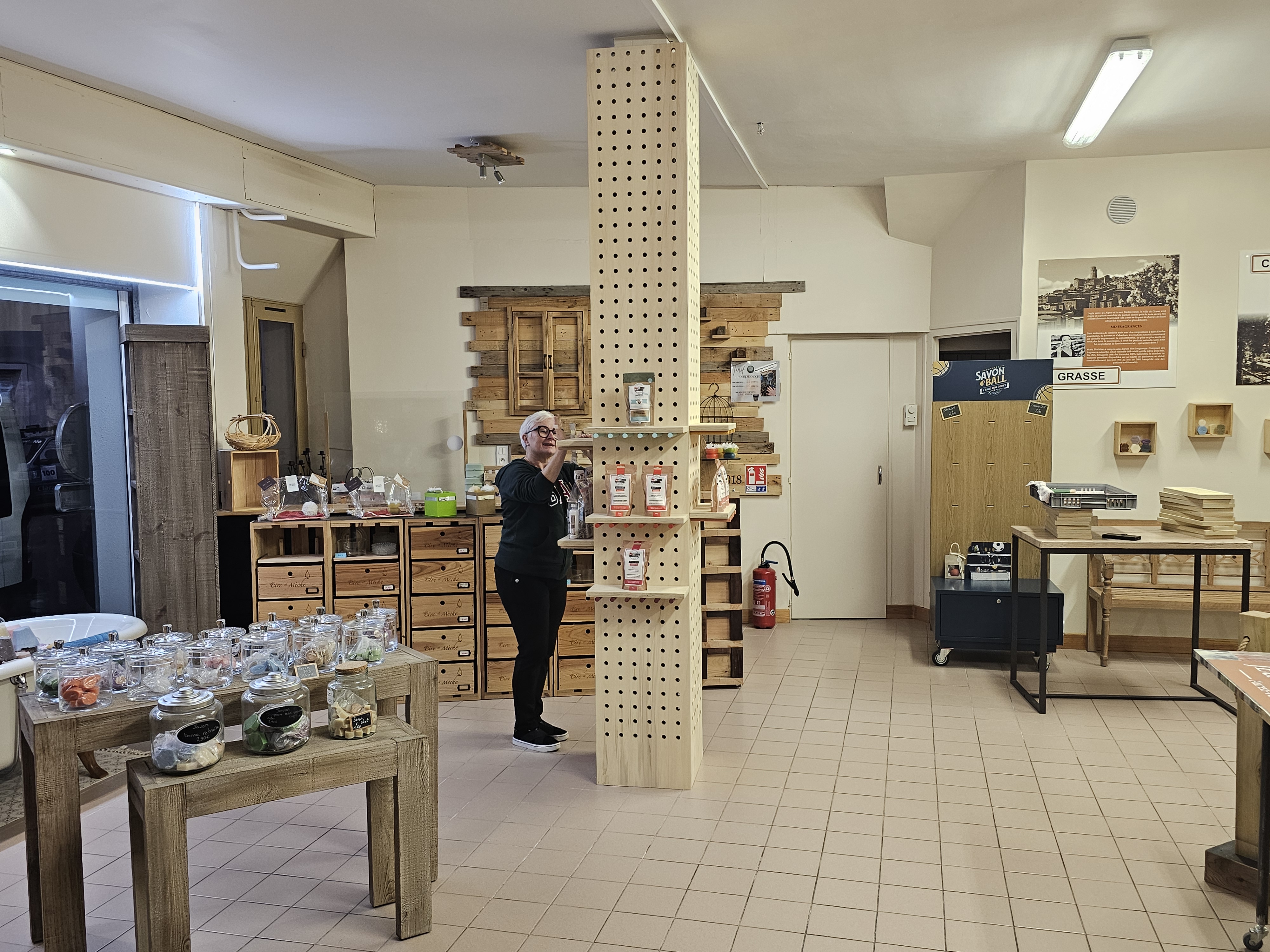 Poteau central en bouleau perforé avec tablettes modulaires dans un magasin artisanal