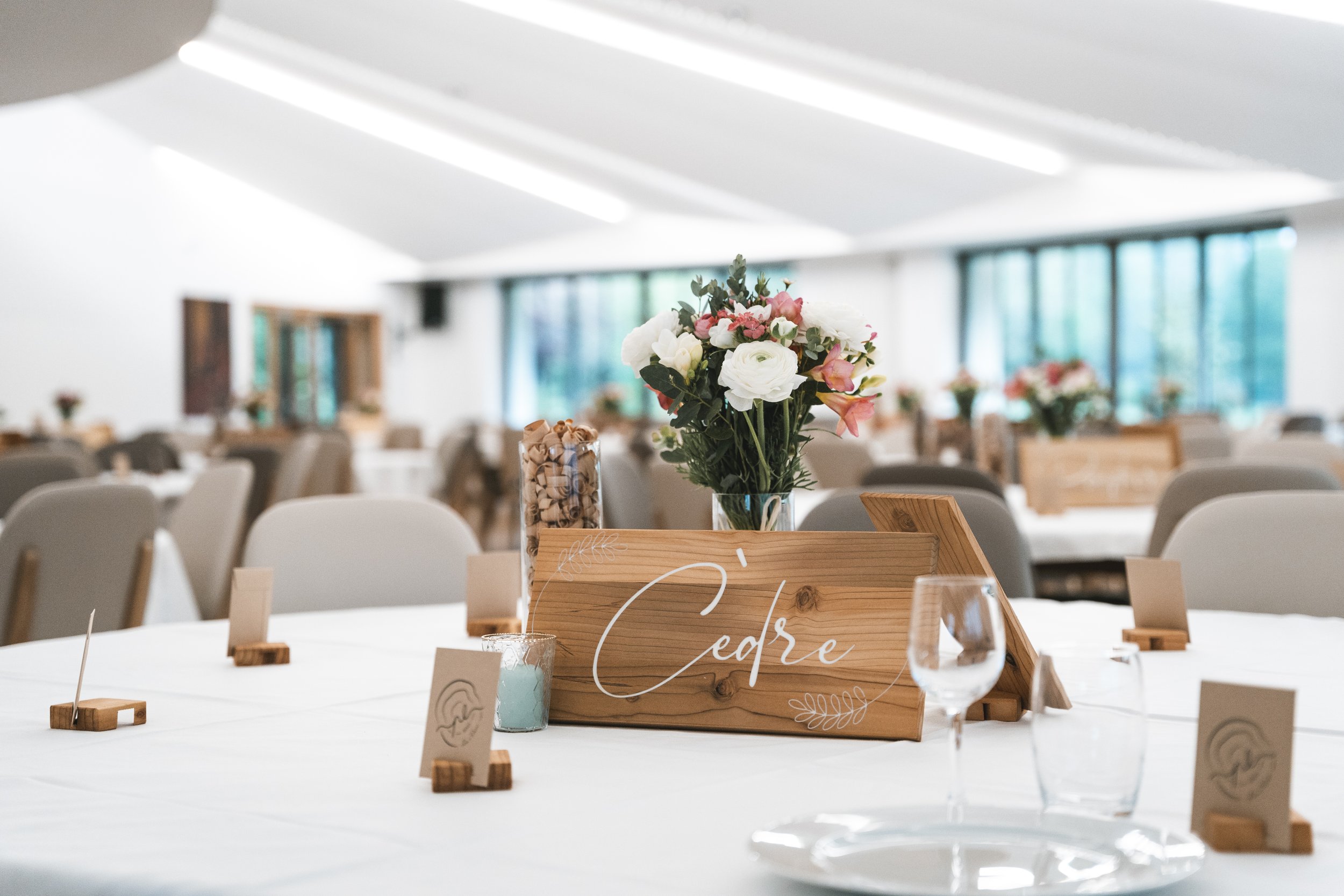 Table de mariage décorée avec nom de table Cèdre en bois calligraphié, marque-places et fleurs
